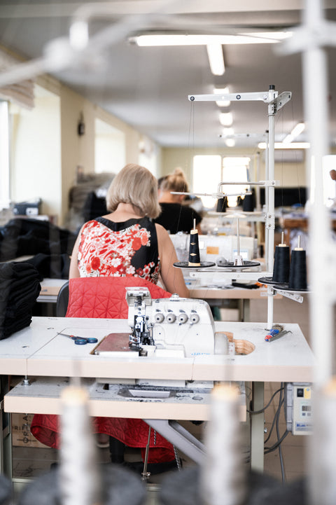 Woman sewing comfortable linen clothing inside production
